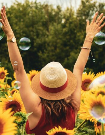 photography of woman surrounded by sunflowers