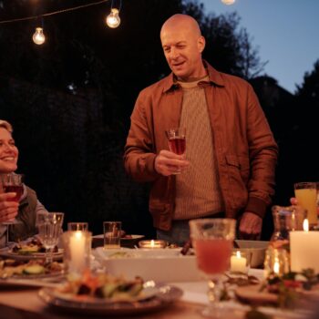 man toasting on family dinner in evening garden