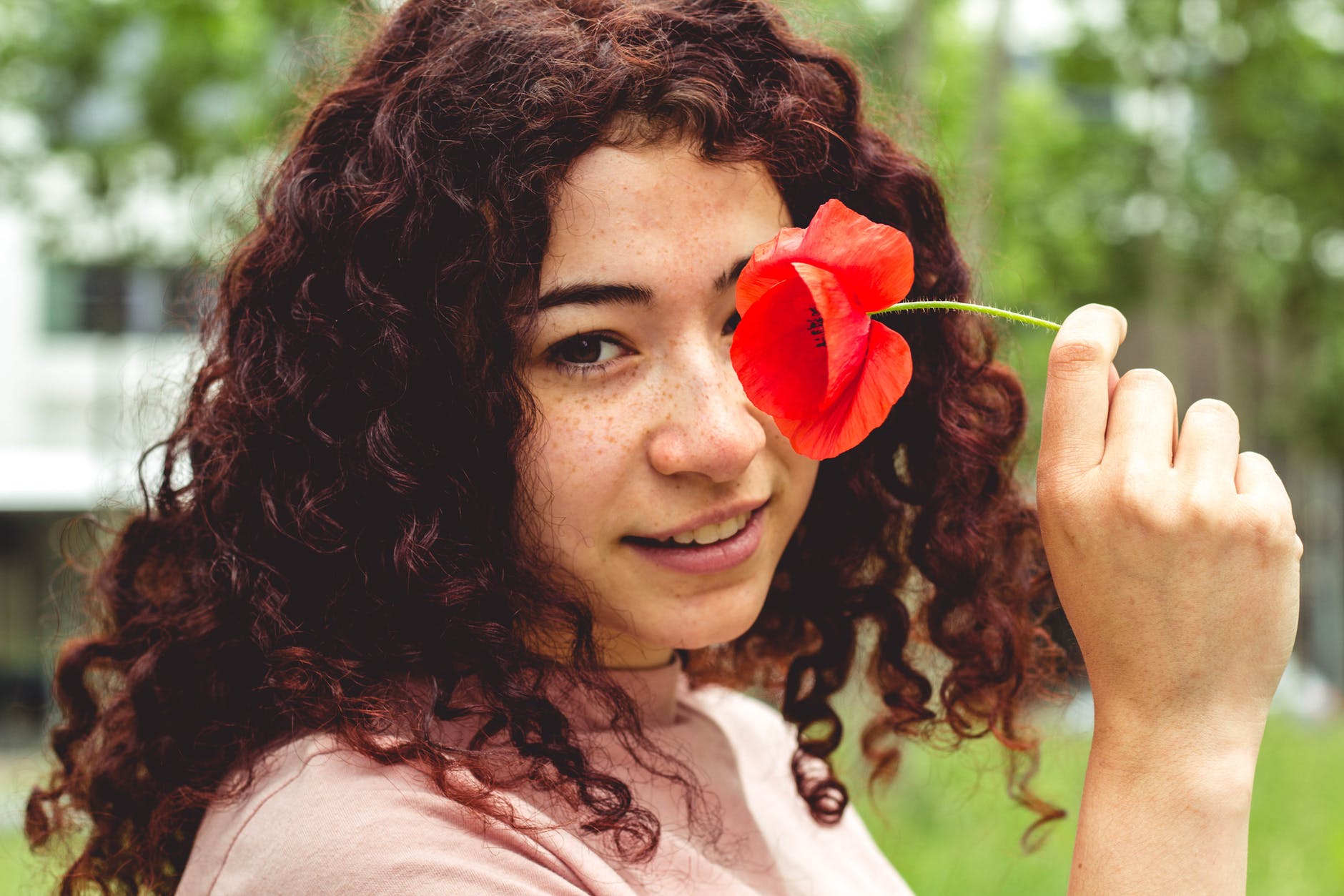 woman holding red flower
