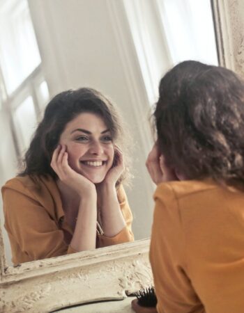 photo of woman looking at the mirror