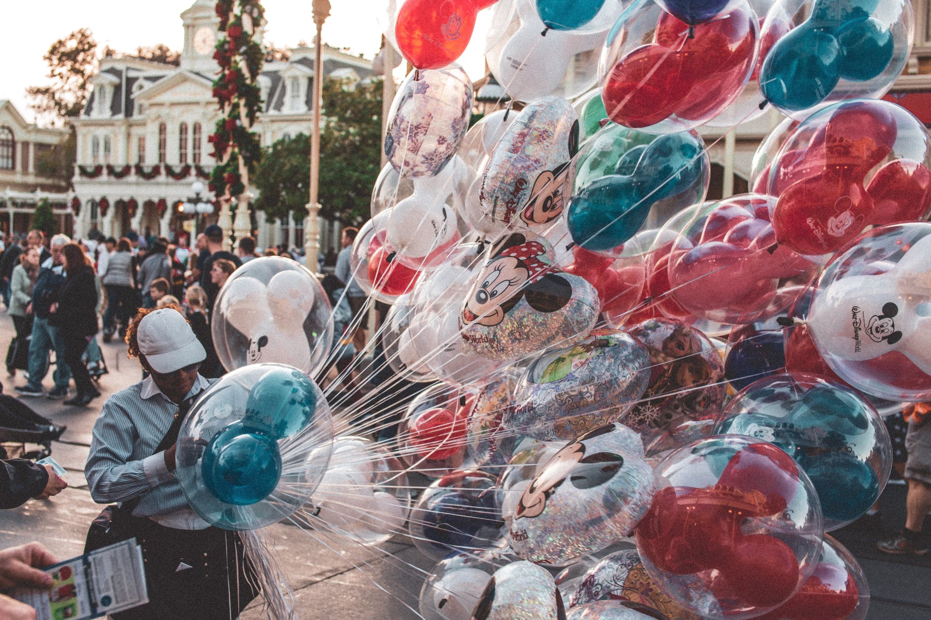 photo of person holding Disney balloons