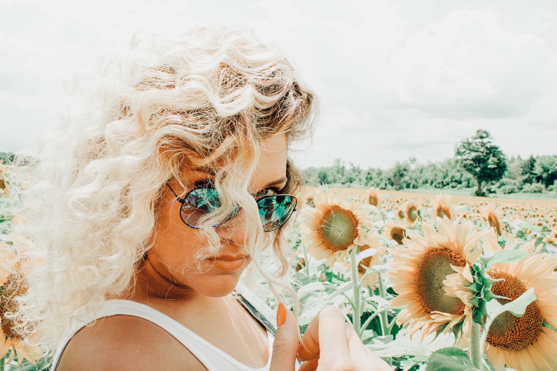 woman wearing sunglasses on sunflower field